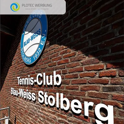 Vereinswappen und Schriftzug Tennis-Club Blau-Weiss Stolberg an einer Backsteinwand